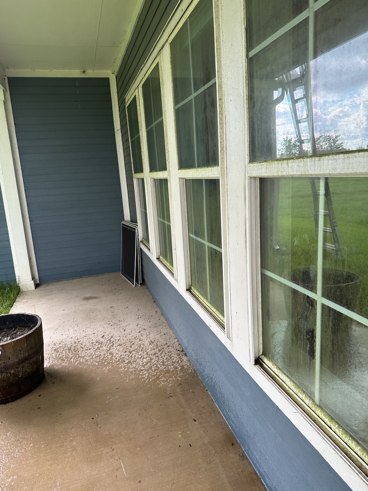 Before: Porch windows and exterior of a blue country home